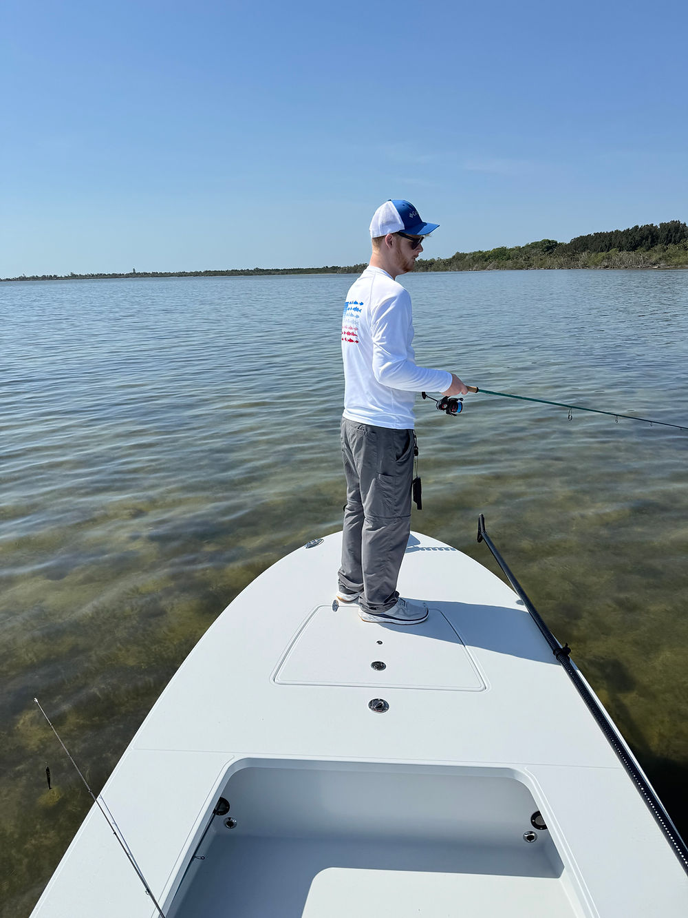 Angler casting from the bow of the flats skiff on the Mosquito Lagoon