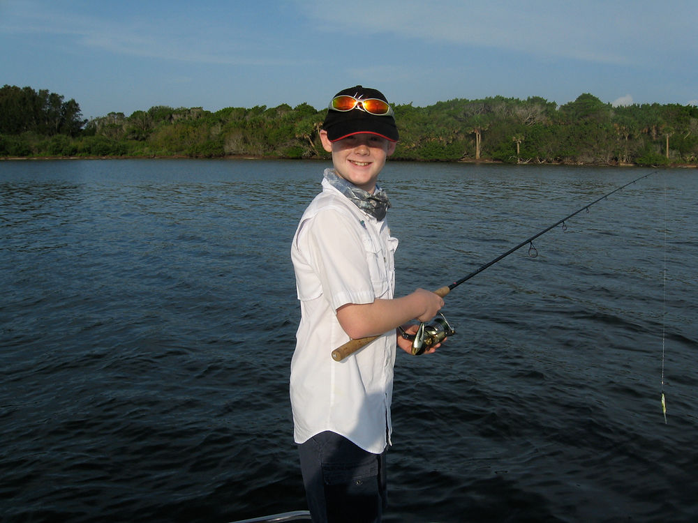 Young angler ready on the water during a family charter